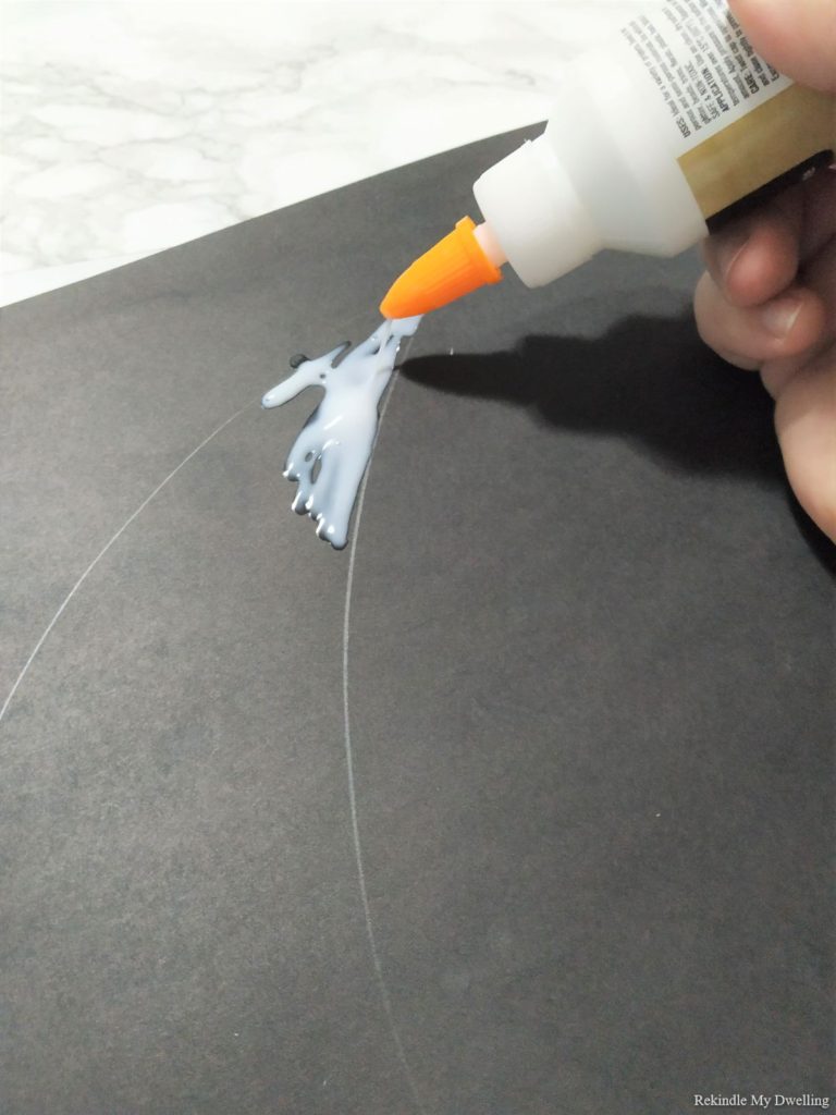 Adding glue to a black paper.
