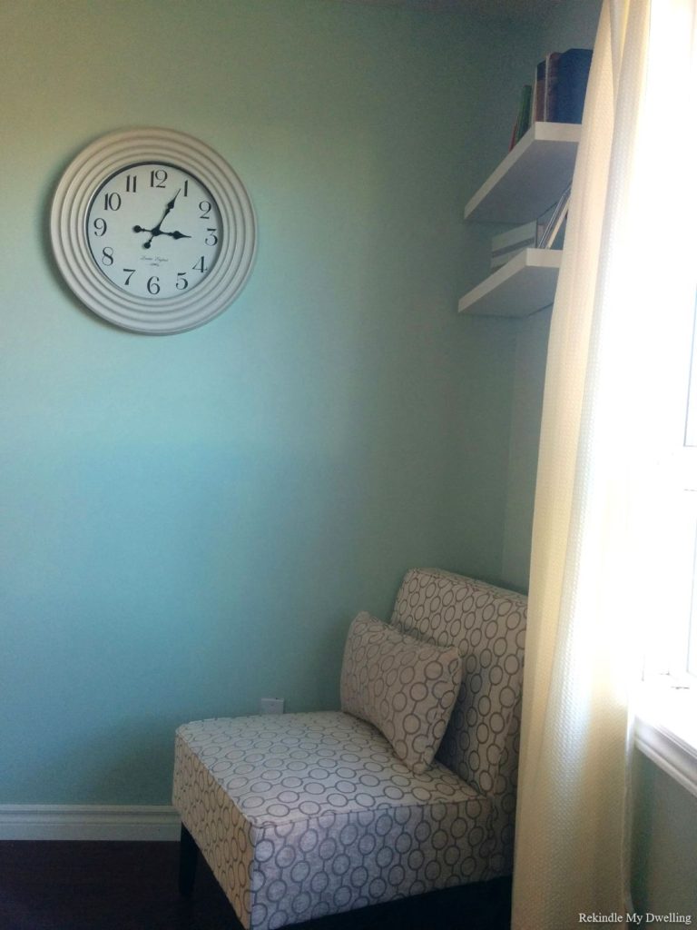 Empty wall with chair and clock.
