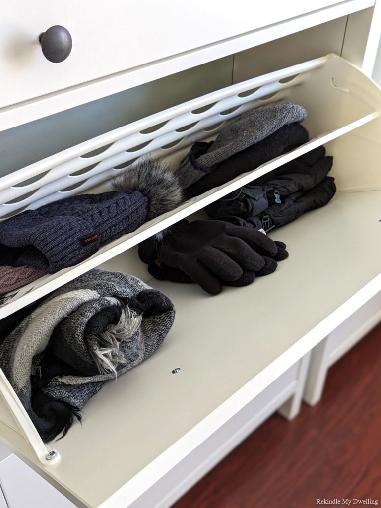 Cabinet filled with hats and mitts.