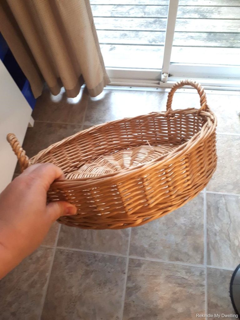 Hand holding a wicker basket.